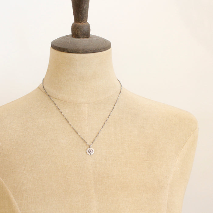 A mannequin wearing the small musana sun necklace