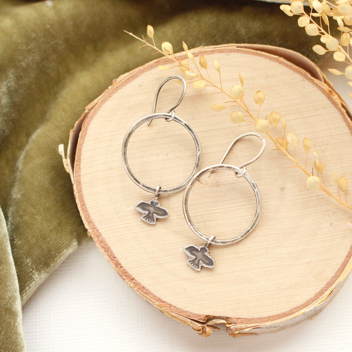 The soar hoop earring styled on wood with green velvet and dried grass
