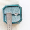 A soar post earring next to a ruler for size reference