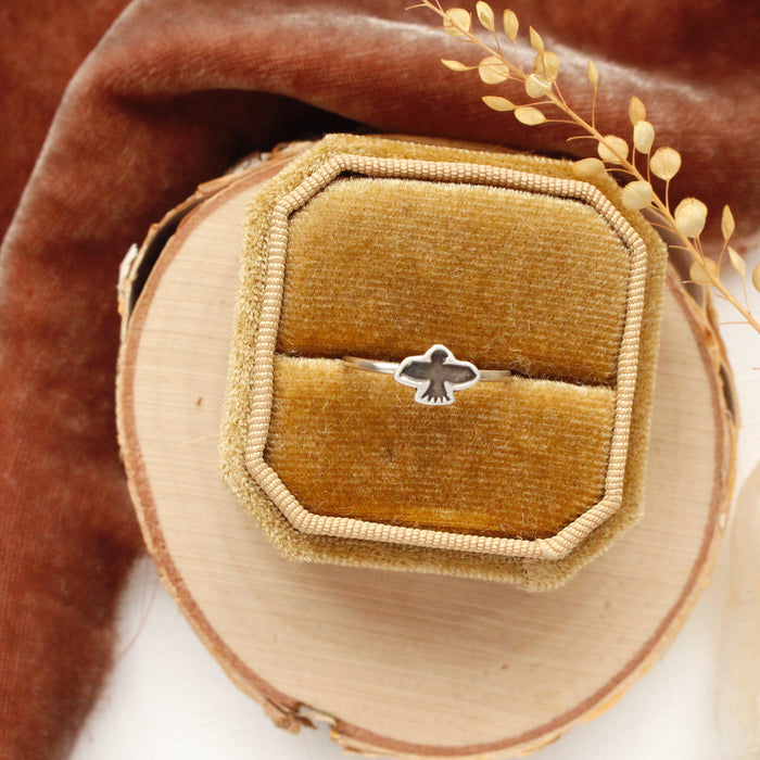 The soar stacking ring is styled in a yellow velvet box with orange velvet and dried grass