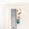 A stacked capri earring next to a ruler for size reference