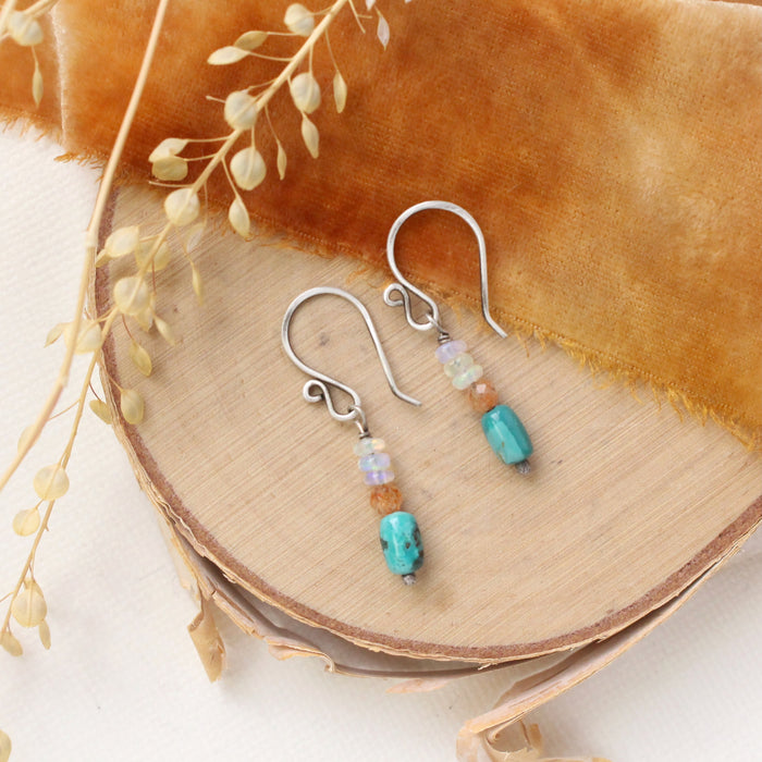 The stacked bondi earrings styled on wood with orange velvet and dried grass