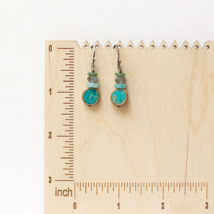 The stacked marin earrings on a wooden ruler for size reference
