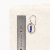 A stacked lapis mini hoop earring next to a ruler for size reference