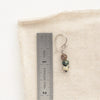 A stacked lona earring next to a ruler for size reference