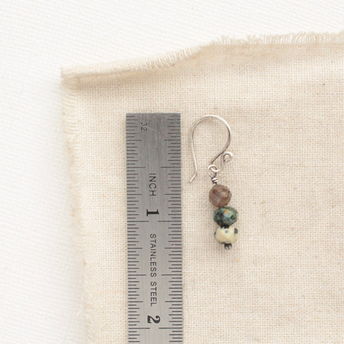 A stacked lona earring next to a ruler for size reference