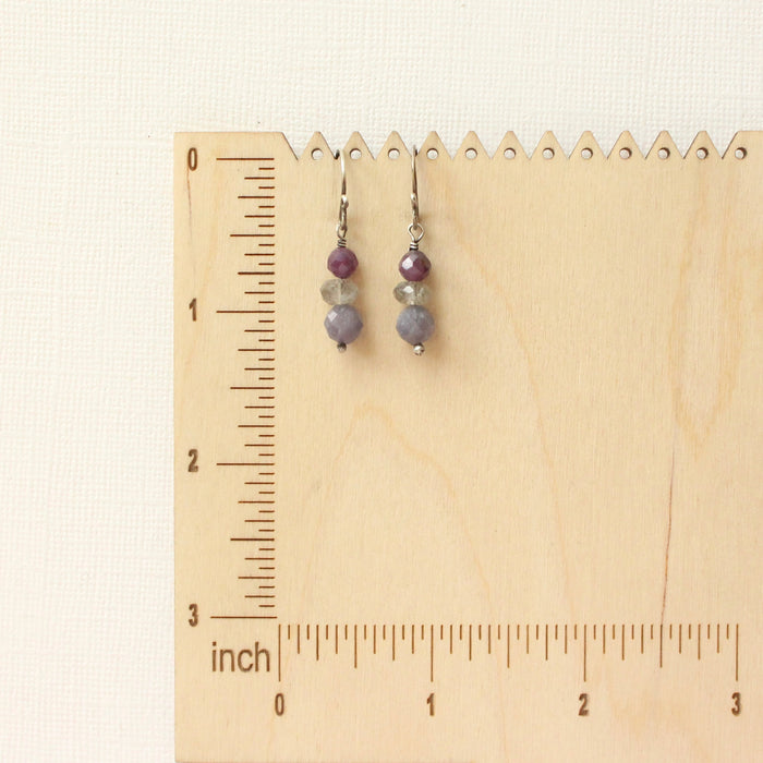 The stacked vinca earrings on a wooden ruler for size reference