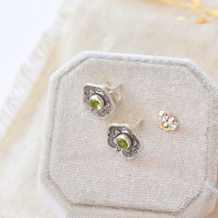The stamped flower peridot post earrings styled to show the butterfly earbacks