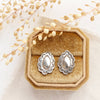 The jolene post earrings styled on a velvet box with linen and dried grass