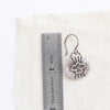 The layered soar earrings next to a ruler for size reference