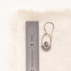 A wanderer hoop earring next to a ruler for size reference