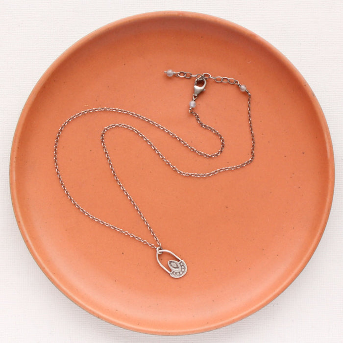 The wanderer hoop necklace styled on an orange plate to show the adjustable lobster clasp closure