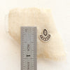 A wanderer post earring next to a ruler for size reference