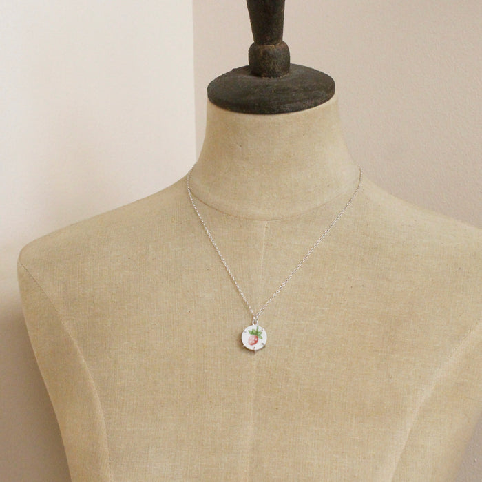 A mannequin wearing the strawberry bud vintage plate necklace