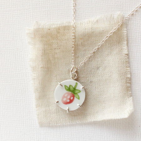 The strawberry bud vintage plate necklace styled on tan linen