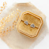 The sun rise post earrings styled on a yellow box with linen and dried grass