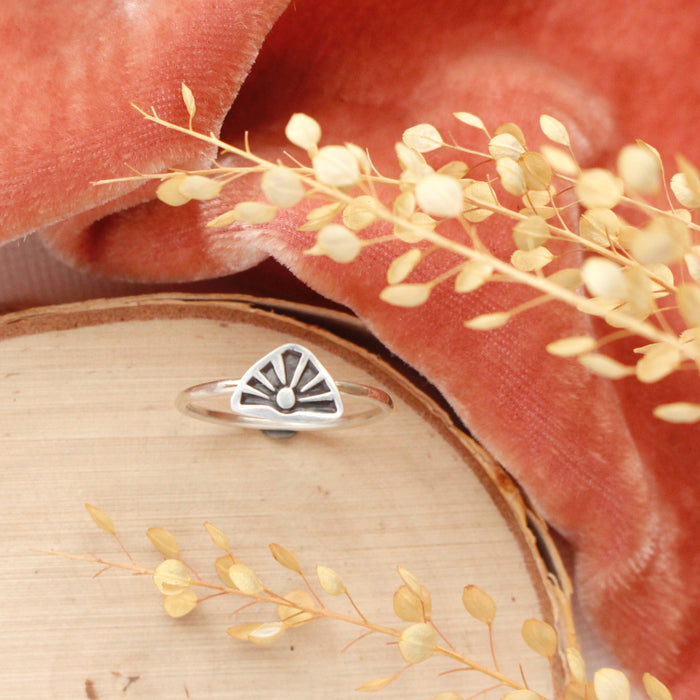The sun rise stacking ring styled on wood with orange velvet and dried grass