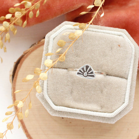 The sun rise stacking ring styled on a velvet box with orange velvet and dried grass