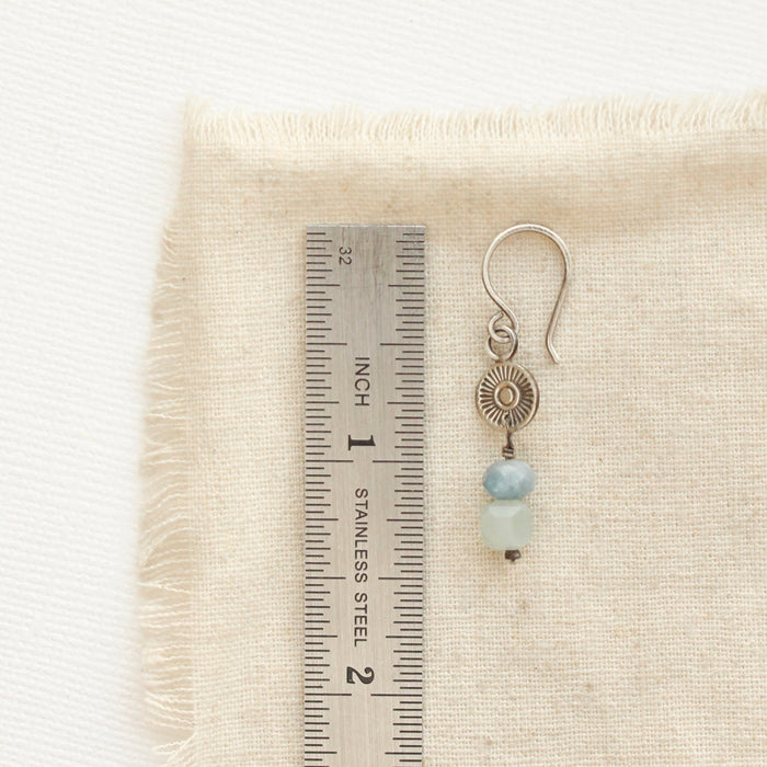 A talara sun aquamarine earring next to a ruler for size reference