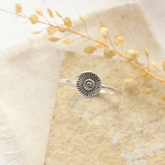The talara sun ring styled on a tan rock with linen and dried grass