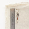 A talara sun zaria earring next to a ruler for size reference