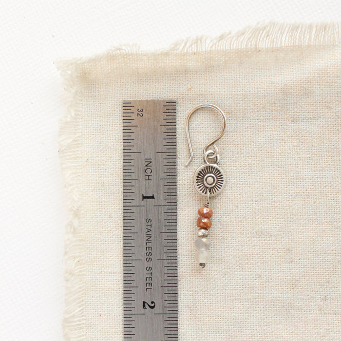 A talara sun zaria earring next to a ruler for size reference