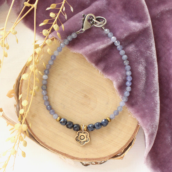 The bronze mini cactus flower vinca bracelet styled on wood with purple velvet and dried grass