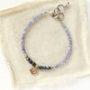 The bronze mini cactus flower vinca bracelet styled on tan linen