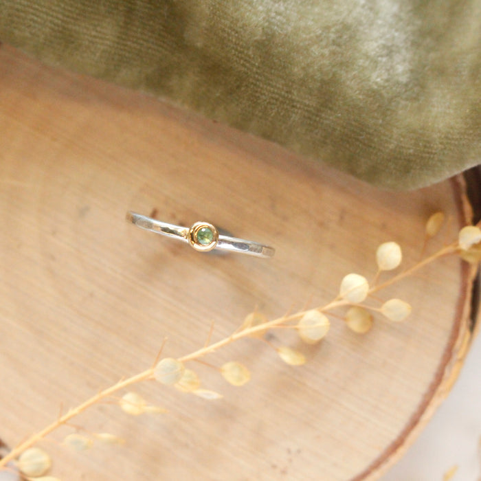 The little green tsavorite mixed metal ring styled on wood with green velvet and dried grass
