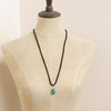 A mannequin wearing the turquoise drop adjustable leather necklace