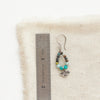 A serenity soar hoop earring next to a ruler for size reference