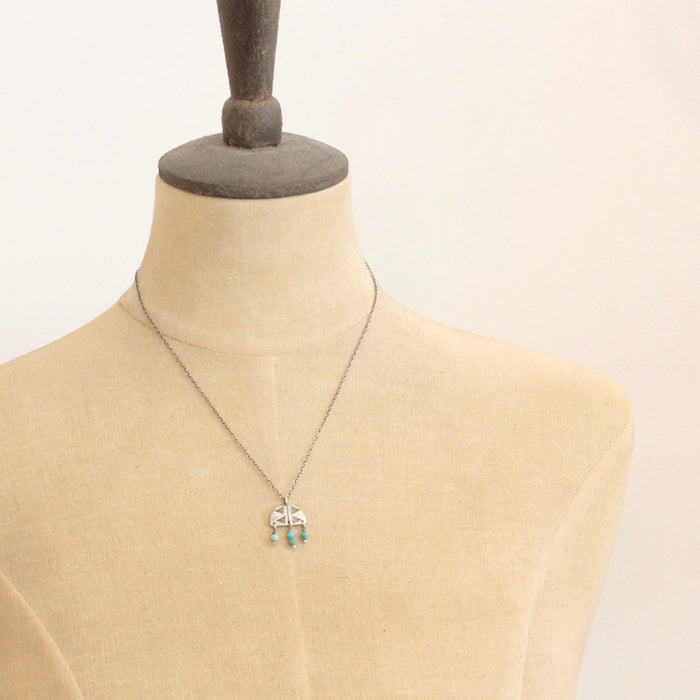 A mannequin wearing the turquoise fringe pakal arch necklace