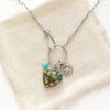 The royston turquoise heart charm necklace styled on tan linen