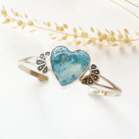 The blue turquoise heart cuff bracelet styled with dried grass