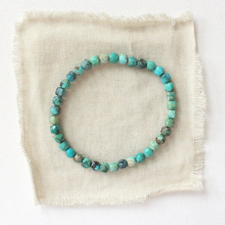 The turquoise cube bracelet styled on tan linen