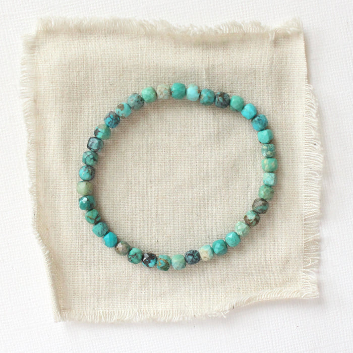 The turquoise cube bracelet styled on tan linen