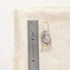 A wanderer arch mixed metal labradorite earring next to a ruler for size reference