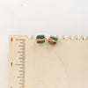 The gold wrapped turquoise square post earrings styled on a wooden ruler to show size reference