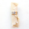 The stamped feather silver band ring styled on rolled tan linen