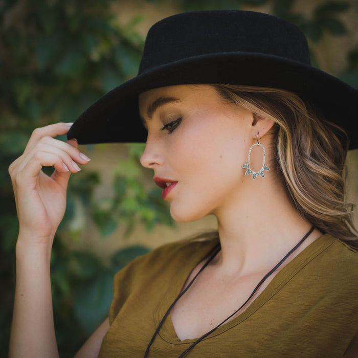 A model wearing the feathered hoop earrings