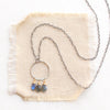 The forged labradorite trio hoop mixed metal necklace is styled on tan linen