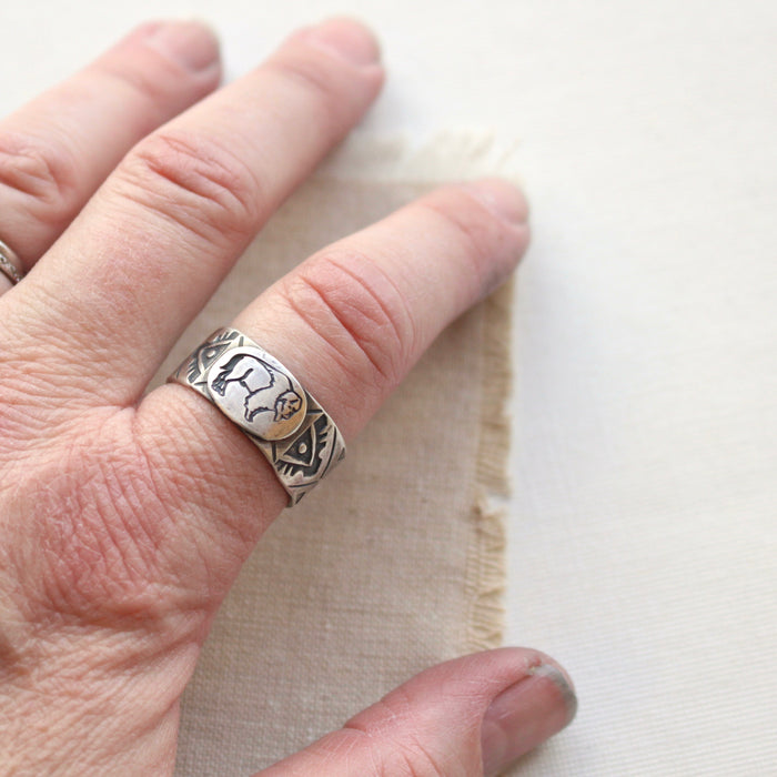 Silver buffalo ring being worn on a pointer finger