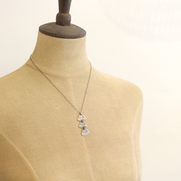 Mannequin wearing stamped silver Asmi trio triangle necklace