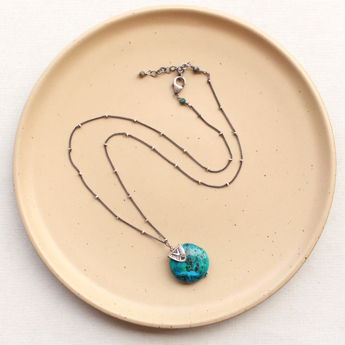 The capped blue and green chrysocolla necklace styled on tan linen to show the adjustable lobster clasp closure