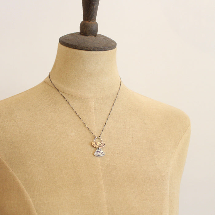 A mannequin wearing the stamped siver and bronze asmi duo necklace