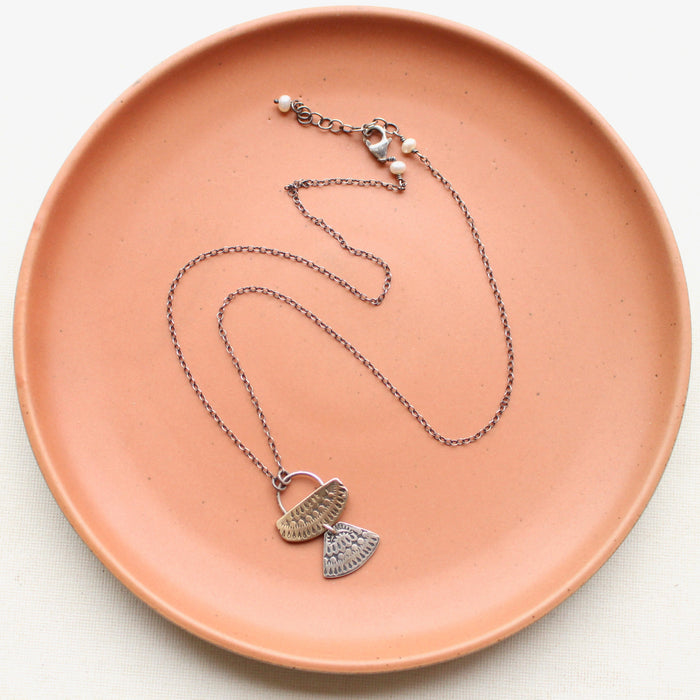 The stamped silver and bronze asmi duo necklace showing the adjustable lobster clasp