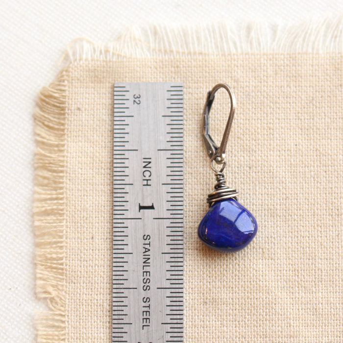 A high quality lapis drop earring next to a ruler for size reference