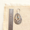A pakal cutout teardrop earring next to a ruler for size reference