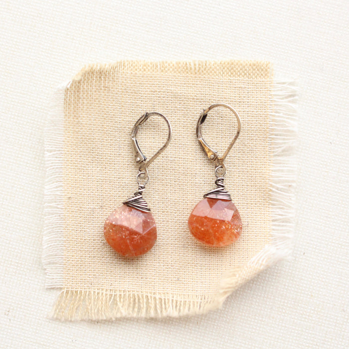 sunstone drop earrings on tan linen