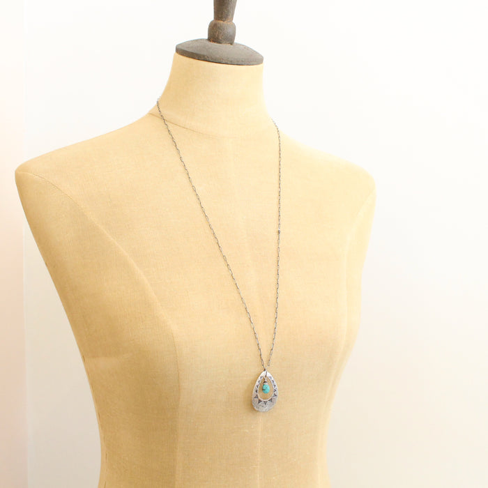A mannequin wearing the pakal teardrop cutout turquoise long necklace